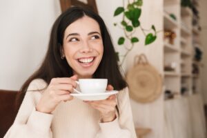 girl smiling while drinking coffee