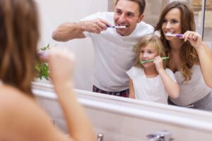 parents demonstrating home dental care for kids