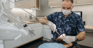 Dentist conducting a procedure on a patient in dentist chair.
