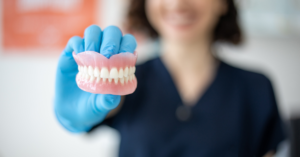 dental hygienist in a dentist's office presenting a new set of affordable dentures to a patient