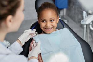 Young girl is happy at her pediatric dentist visit in midlothian va to care for her baby teeth.