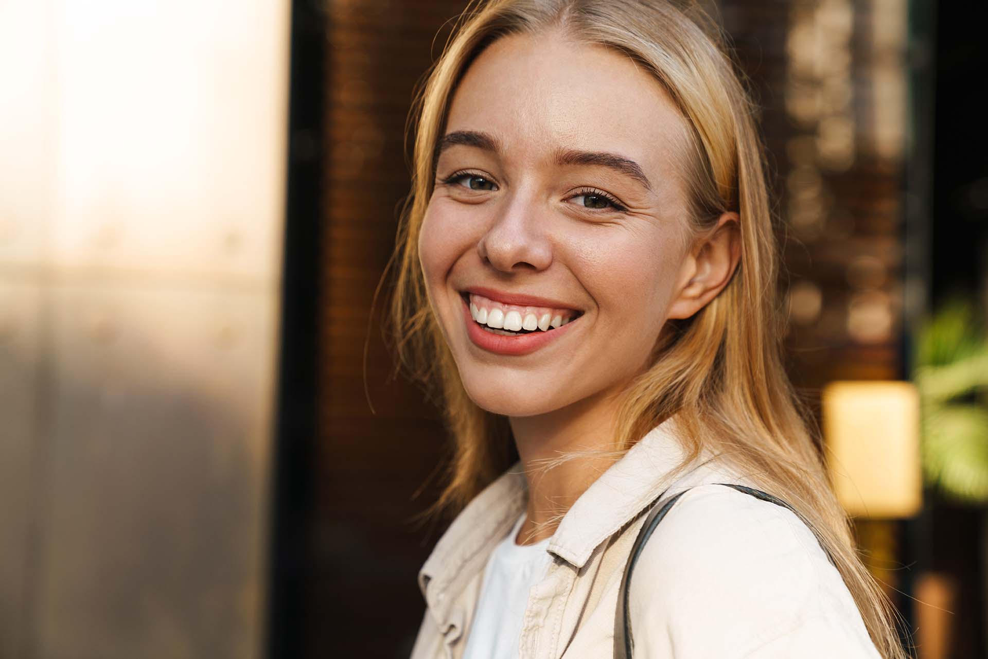 Close up of a smiling young woman walking outdoors