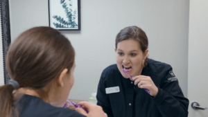 Joslyn Wolberg demonstrates teeth brushing and shows patients the best time of day to brush teeth.